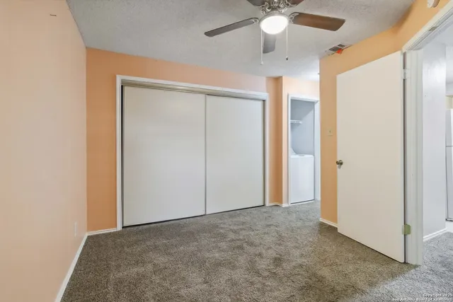 a view of an empty room with a ceiling fan
