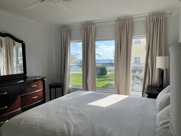 a bedroom with a bed and a dresser next to a window