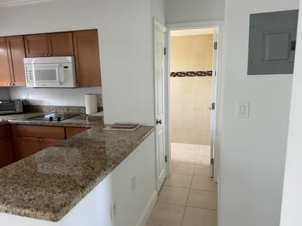 a kitchen with a granite countertop sink and cabinets