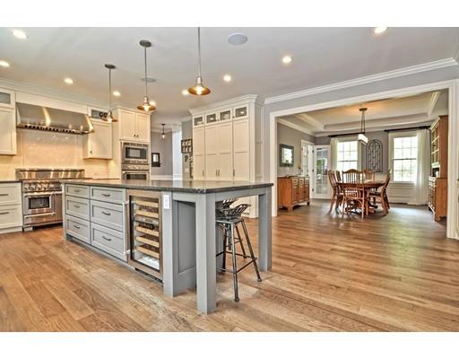 2 Snowy Owl Road Hopkinton, MA 01748 - Photo 4 of 30 a kitchen with stainless steel appliances granite countertop a stove top oven a dining table and chairs