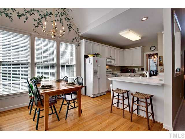 1808 Small Court Raleigh, NC 27612 - Photo 6 of 19 Plenty of space in the breakfast room for day to day meals plus a breakfast bar area. Open vaulted ceiling with two walls of windows and access through french door to deck. Breakfast Area