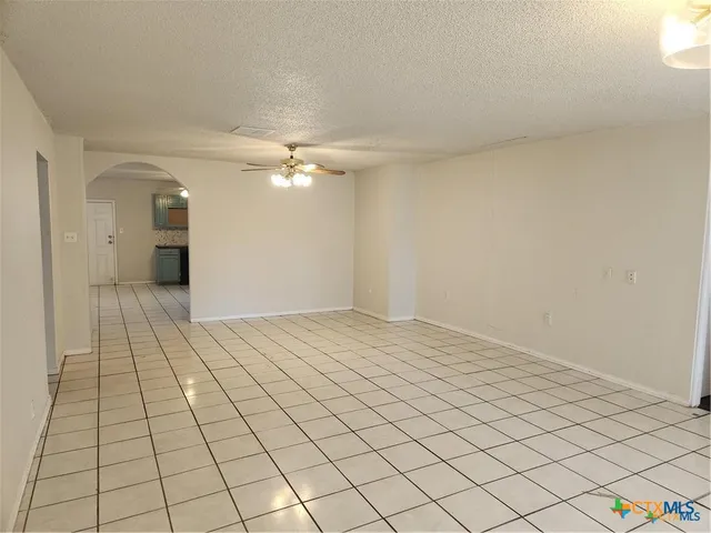 a view of a livingroom with an empty space and a chandelier fan