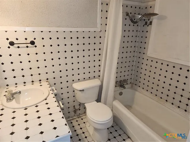 a white toilet sitting next to a bathroom sink