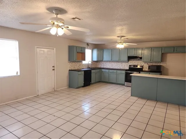 a kitchen with stainless steel appliances granite countertop a sink and cabinets