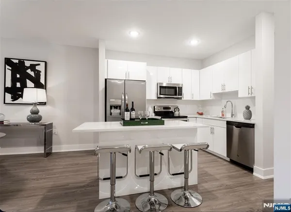 a kitchen with white cabinets and stainless steel appliances