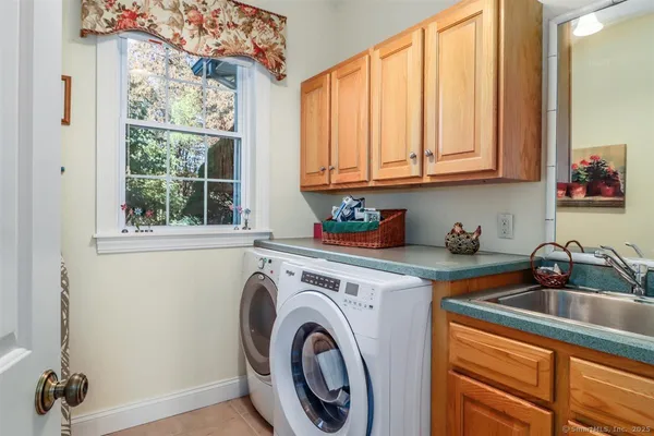 a kitchen with stainless steel appliances granite countertop a sink a washer and dryer next to a window