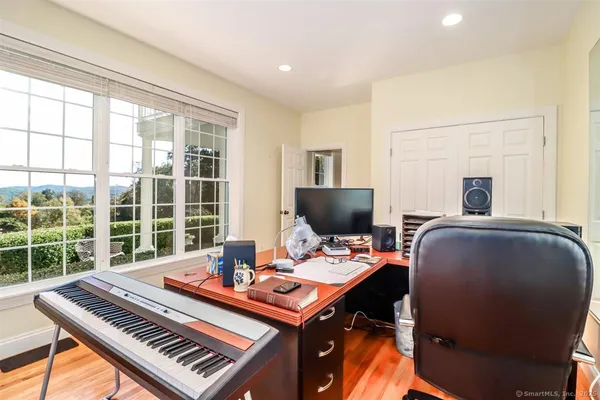 a view of a workspace with furniture and a window