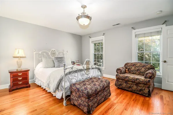 a bedroom with bed couch and window
