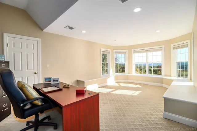 a workspace with furniture and a large window