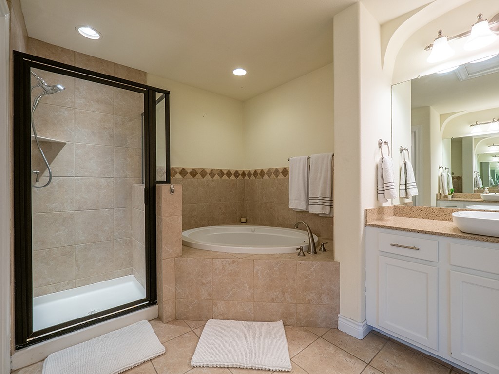 3609 Clawson Road, Unit B Austin, TX 78704 - Photo 15 of 28 Bathroom featuring a tiled soaking tub and a glass-enclosed shower with a built-in shelf