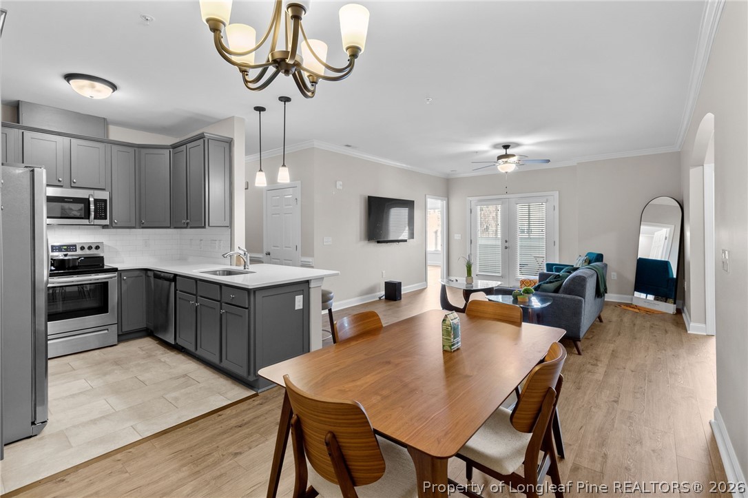 288 Gallery Drive, Unit 301 Spring Lake, NC 28390 - Photo 8 of 36 a large kitchen with a table chairs stainless steel appliances and cabinets