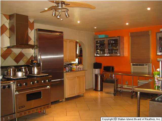 53 Belair Road Staten Island, NY 10305 - Photo 6 of 14 a kitchen with stainless steel appliances kitchen island granite countertop a table and chairs in it