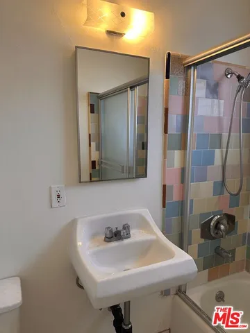 a white toilet sitting next to a shower