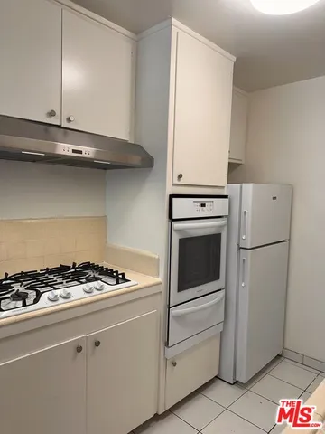 a kitchen with white cabinets and white appliances