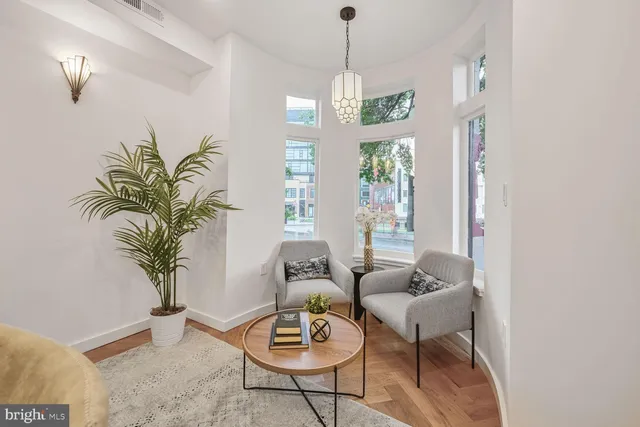 a living room with furniture potted plant and a chandelier