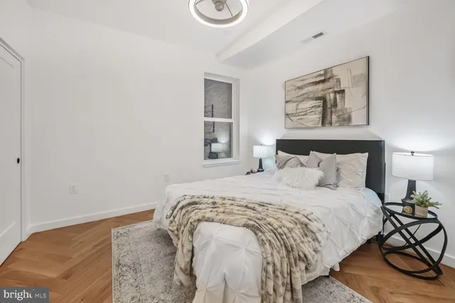 a bedroom with a bed and painting on the wall