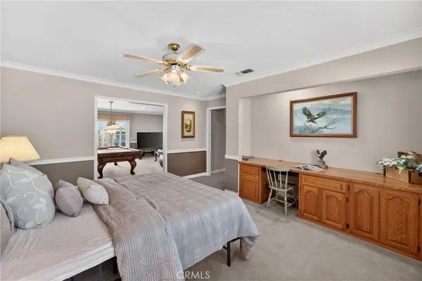 a spacious bedroom with a bed and a chandelier
