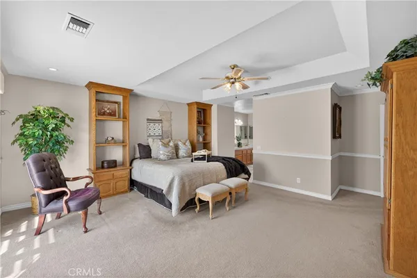 a bedroom with a bed a ceiling fan and a dresser