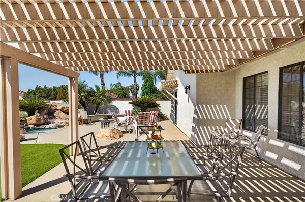 a view of a patio with table and chairs with wooden floor and fence