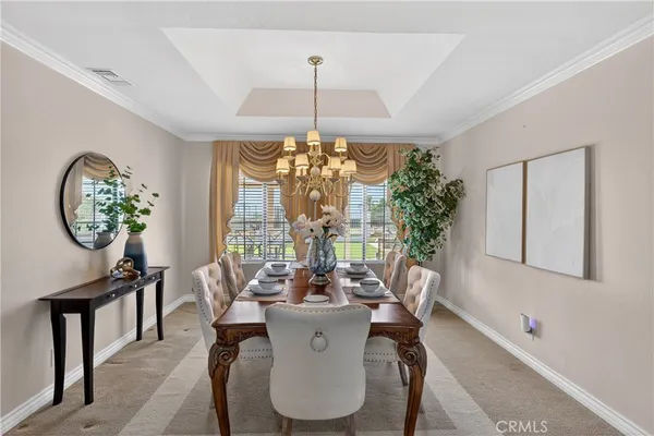 a dining room with furniture a chandelier and window