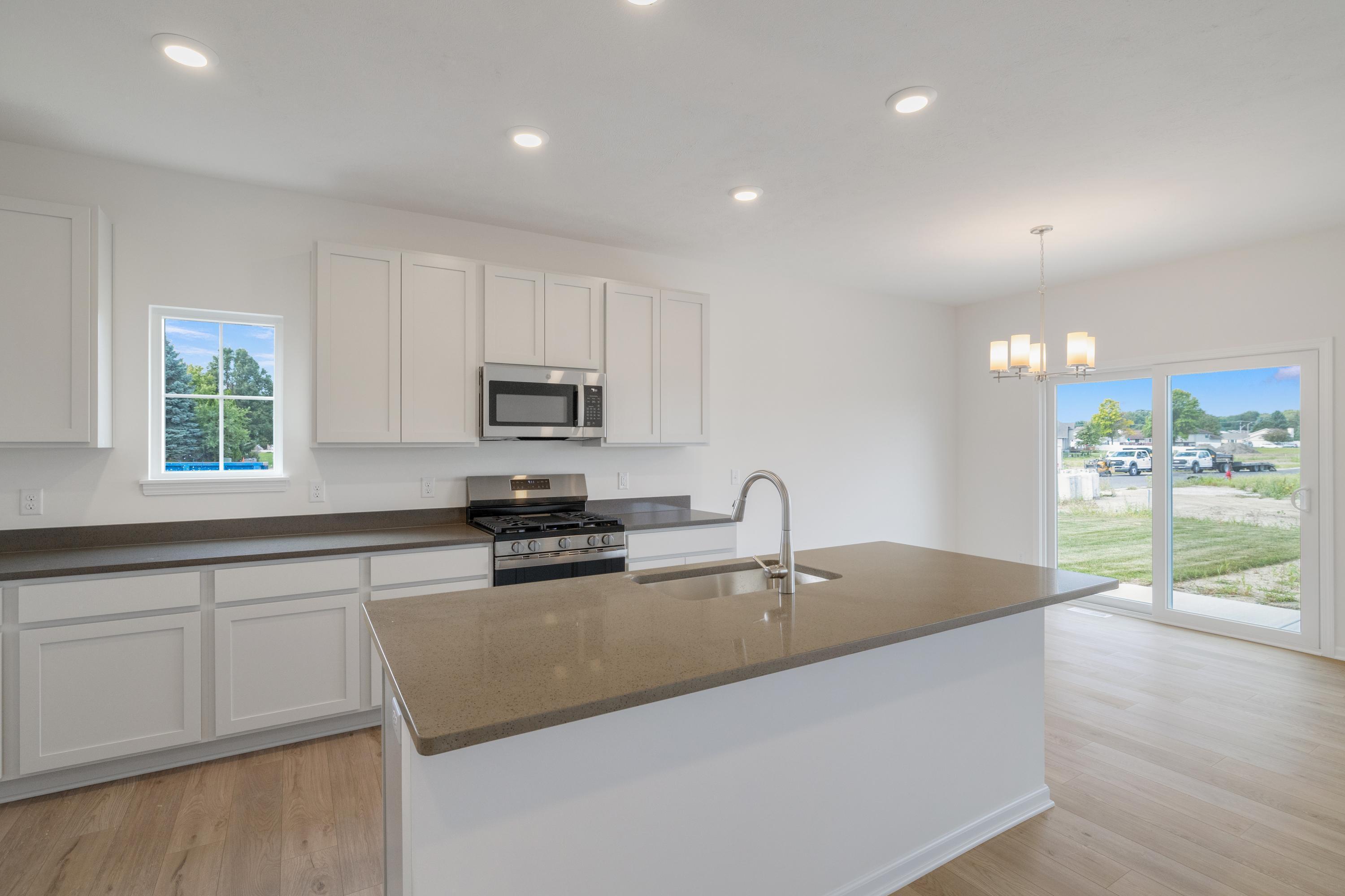 6852 Tucson Road Schererville, IN 46375 - Photo 9 of 28 a kitchen with granite countertop a sink a stove and cabinets