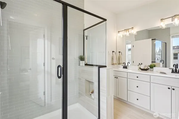 a bathroom with a double vanity sink mirror and shower