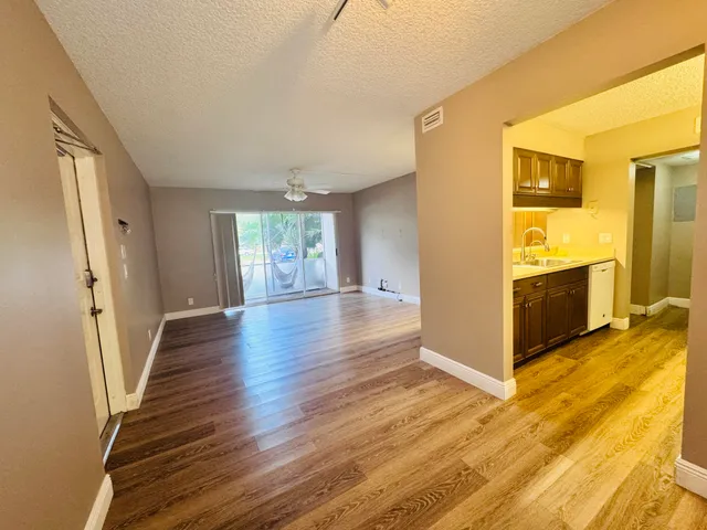 a view of a kitchen with wooden floor and electronic appliances