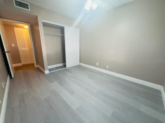 an empty room with wooden floor and entrance