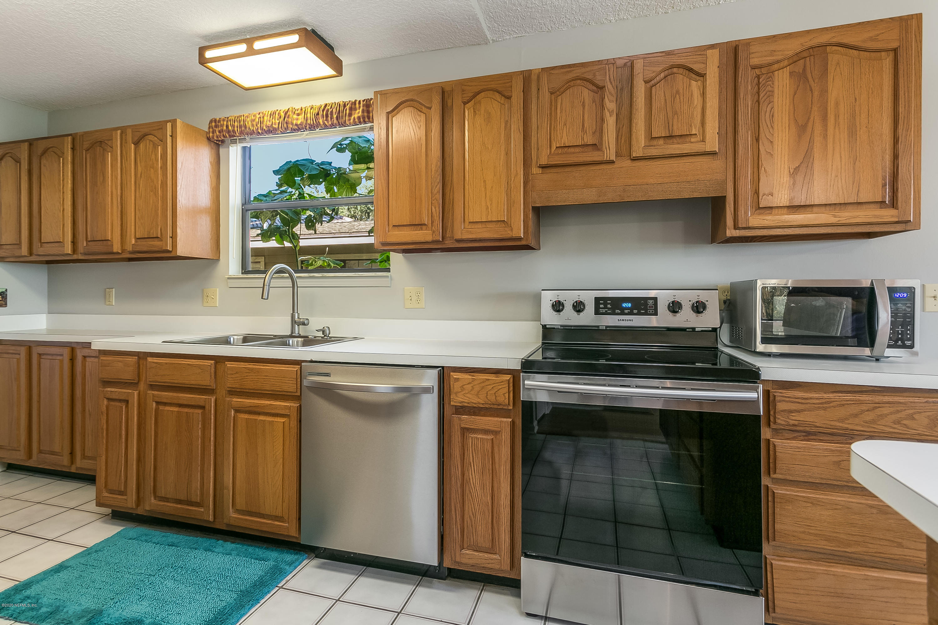 4239 Magnolia Road Orange Park, FL 32065 - Photo 13 of 40 a kitchen with stainless steel appliances granite countertop a stove a sink and a microwave