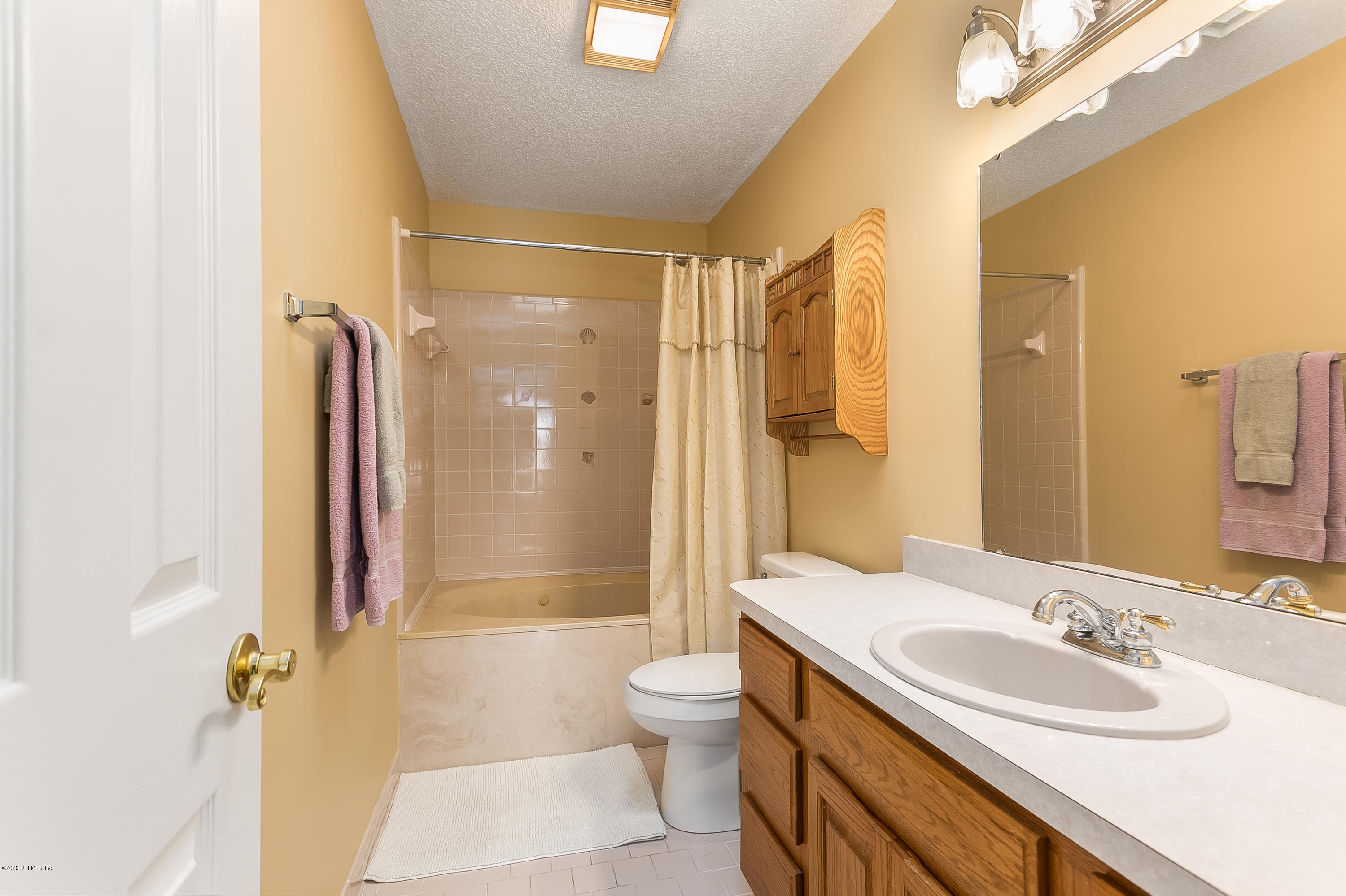 4239 Magnolia Road Orange Park, FL 32065 - Photo 28 of 40 a bathroom with a double vanity sink toilet mirror and shower