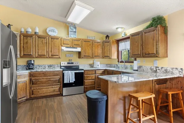 a kitchen with stainless steel appliances granite countertop a sink stove and refrigerator