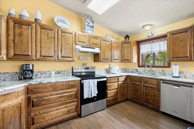 a kitchen with stainless steel appliances granite countertop a sink and cabinets