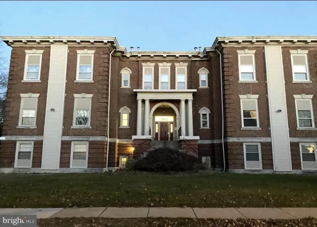 a front view of a residential apartment building with a yard