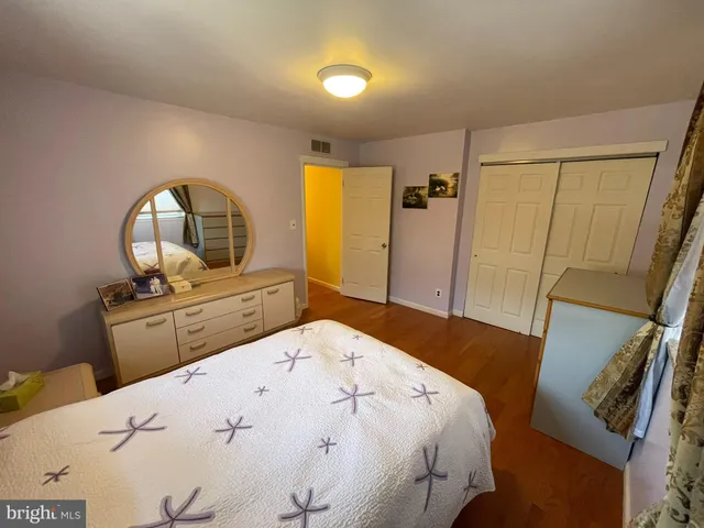 a living room with a bed furniture and a flat tv screen on dresser