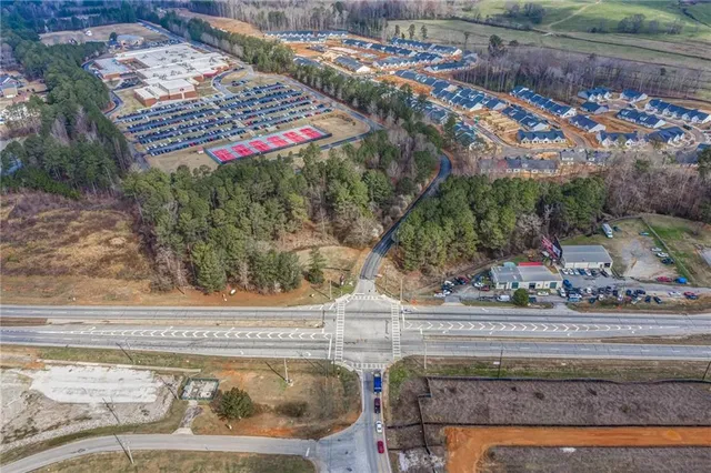 an aerial view of residential houses with outdoor space and trees