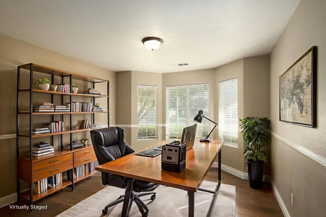 a view of a workspace with furniture and a window