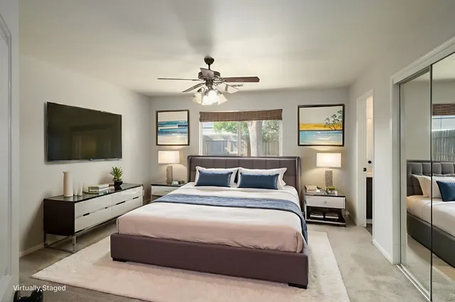 a bedroom with a bed a window and a flat screen television