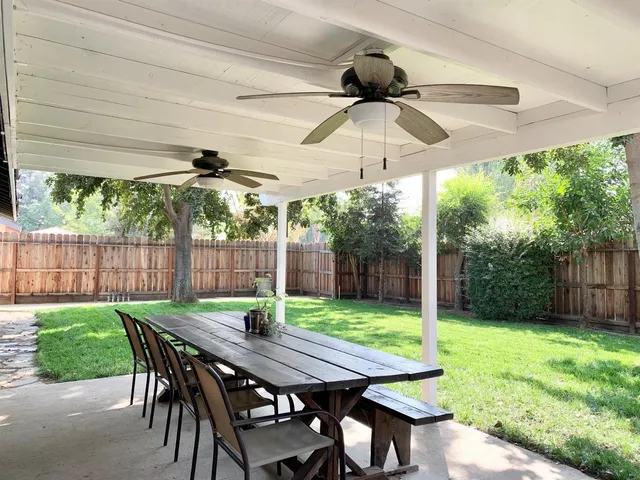 a view of a patio with a table chairs and a backyard