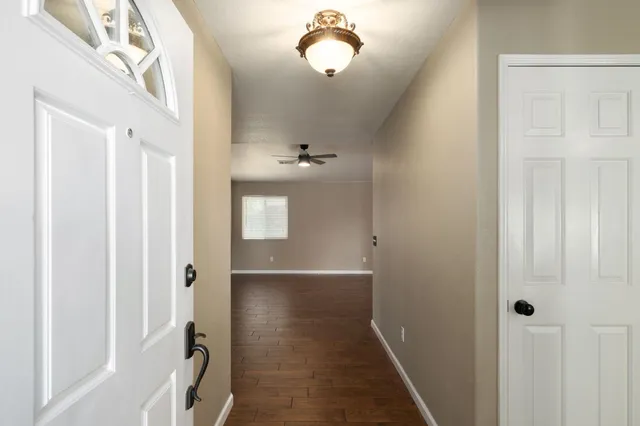 a view of a hallway with wooden floor and closet