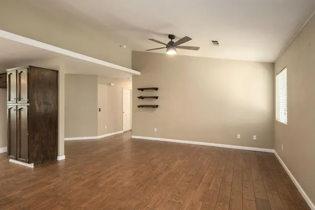 an empty room with closet and a ceiling fan