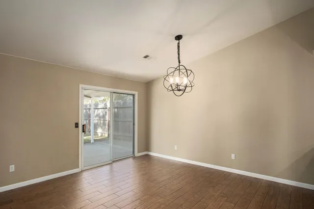 a view of a room with a wooden floor and chandelier