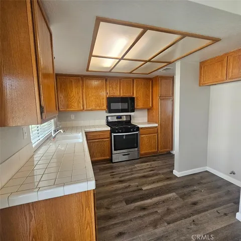 a kitchen with wooden floors and stainless steel appliances
