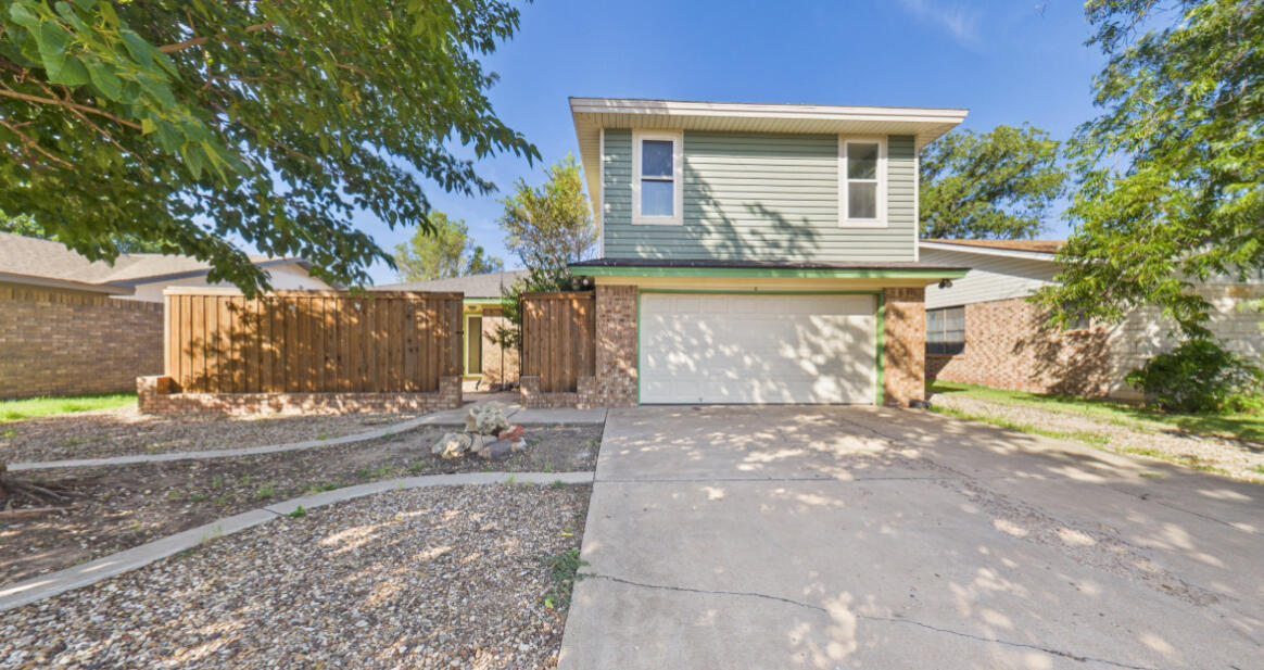 a view of a house with a yard and tree s