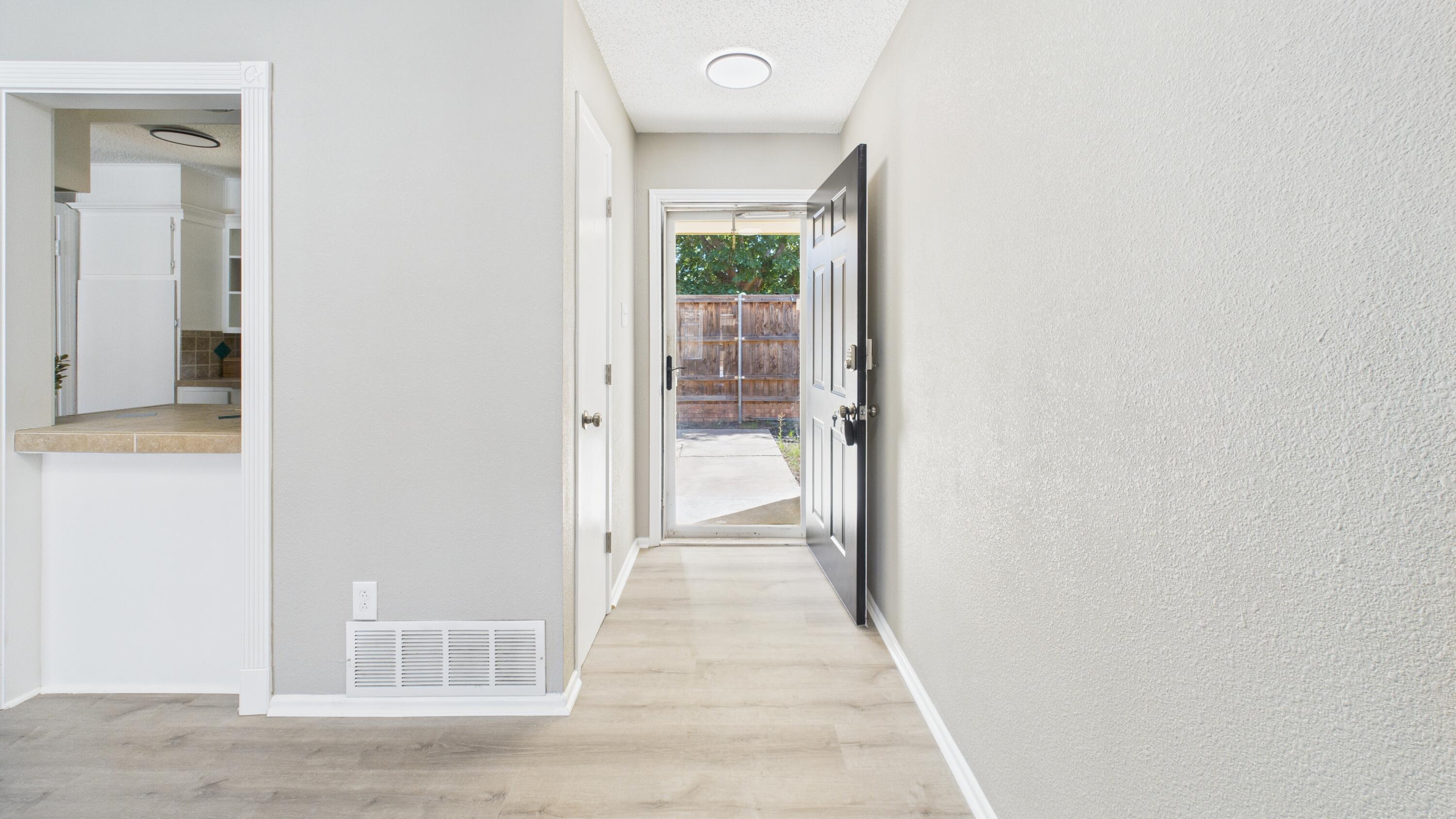 5719 2nd Street Lubbock, TX 79416 - Photo 16 of 61 a view of a hallway with wooden floor and a bathroom