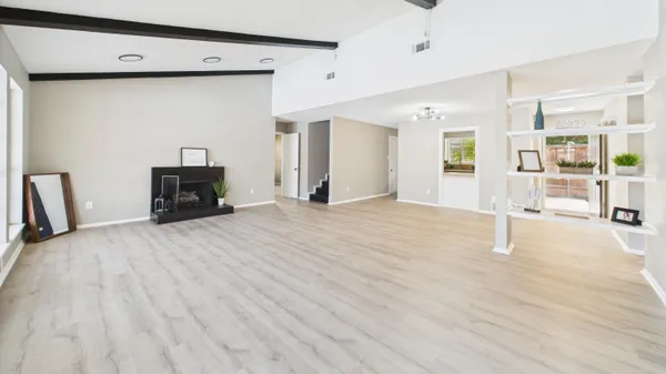 a view of a hallway with wooden floor and a living room