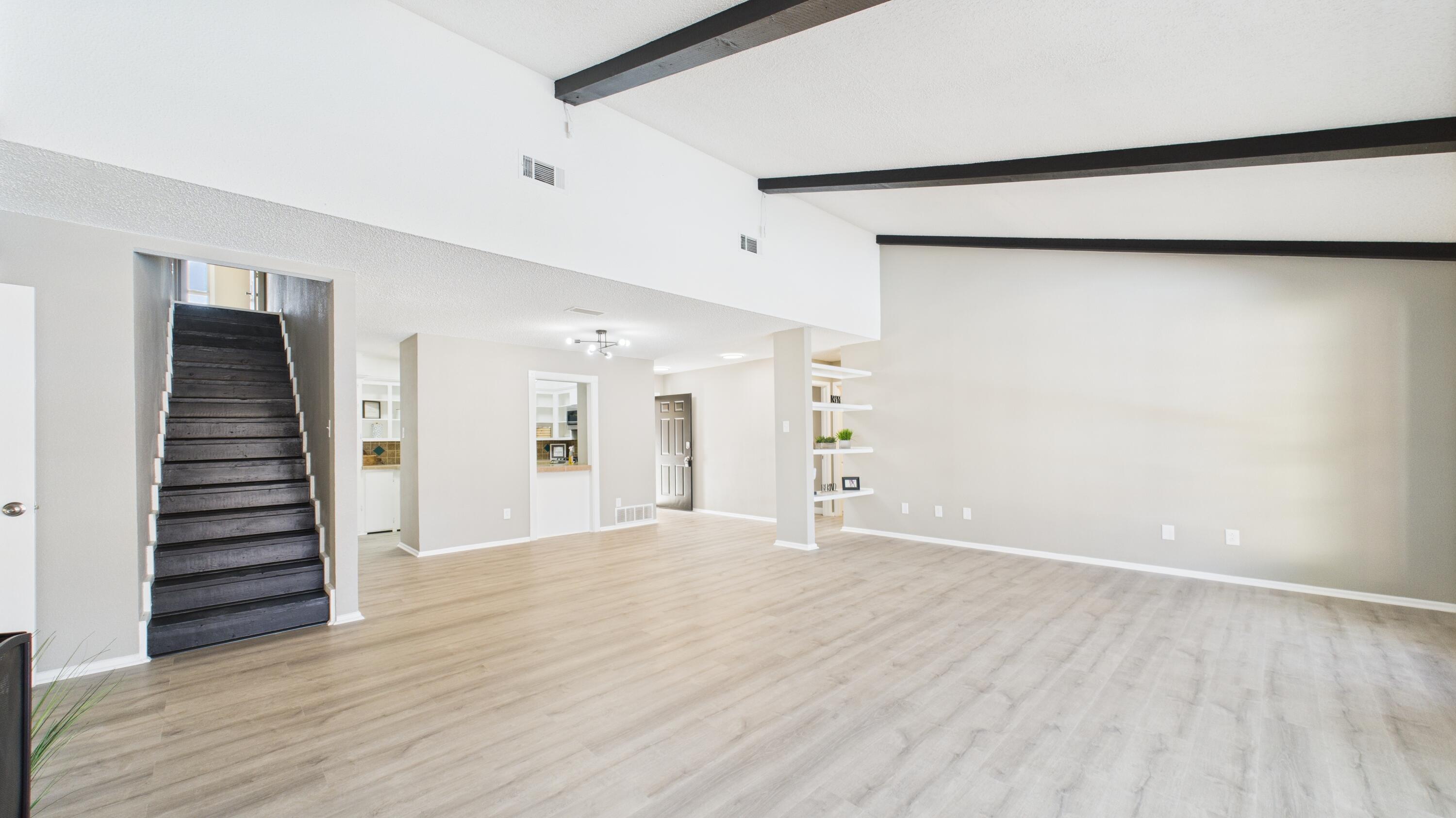 5719 2nd Street Lubbock, TX 79416 - Photo 23 of 61 a view of an empty room with wooden floor and stairs
