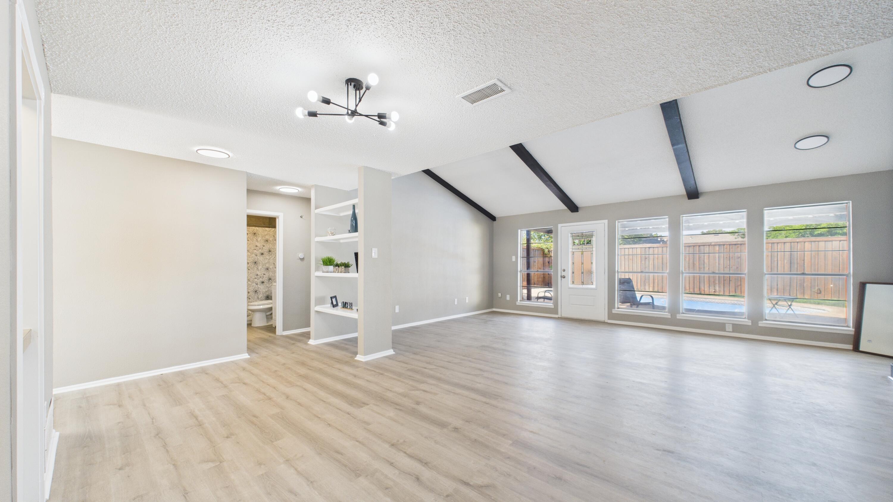 5719 2nd Street Lubbock, TX 79416 - Photo 30 of 61 a view of an empty room with wooden floor and a window