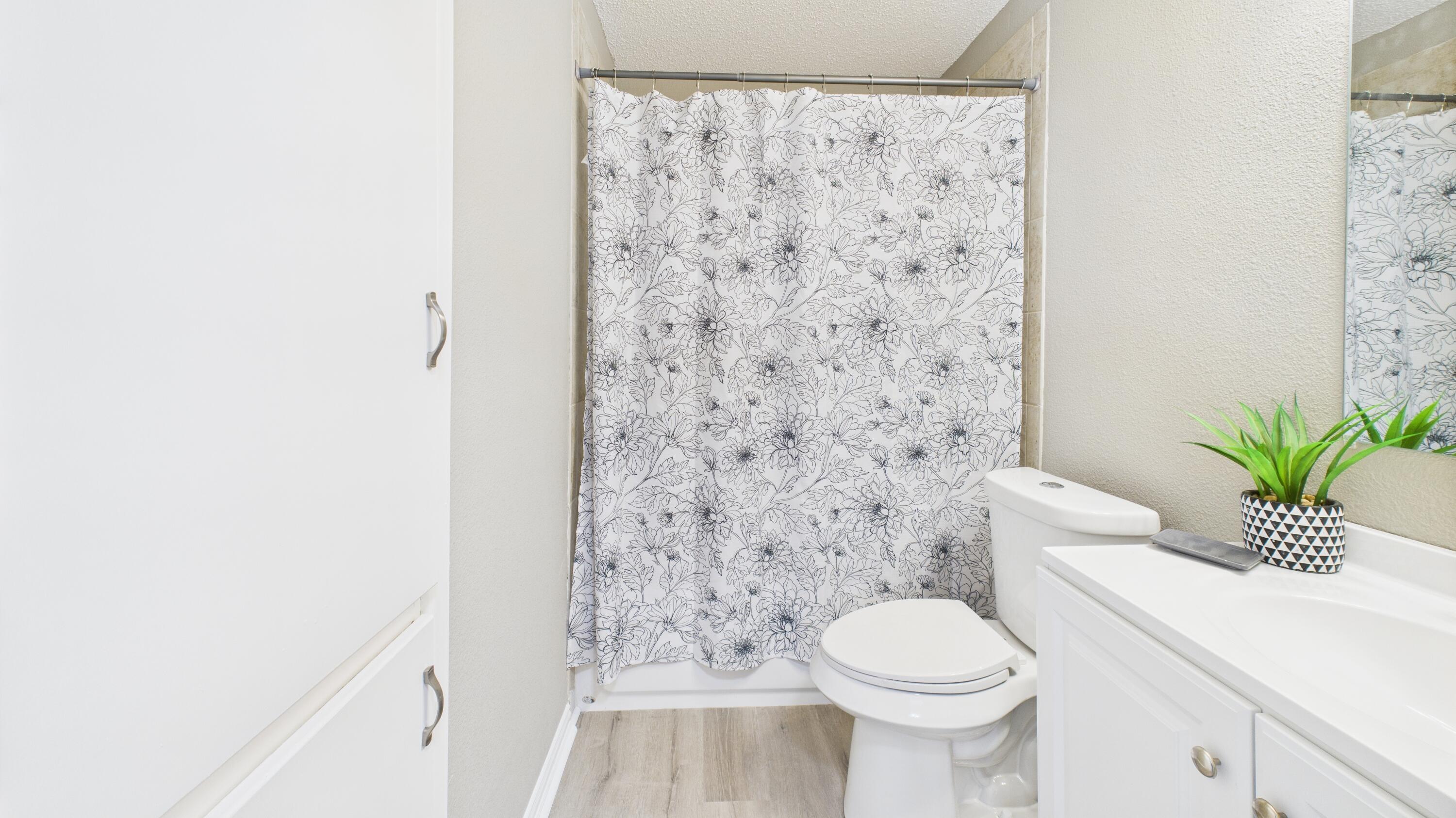 5719 2nd Street Lubbock, TX 79416 - Photo 32 of 61 a bathroom with a toilet and a shower curtain