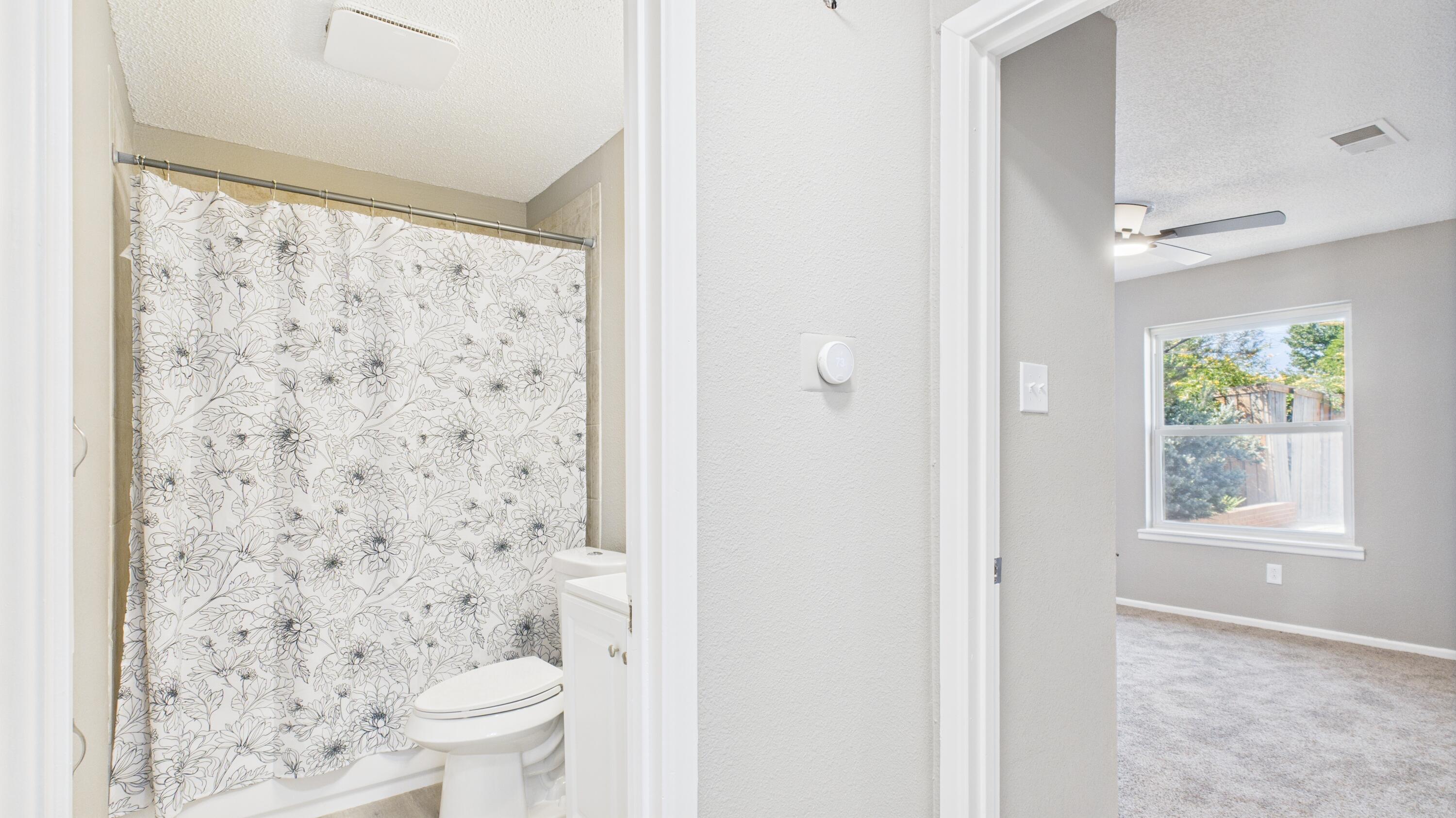 5719 2nd Street Lubbock, TX 79416 - Photo 35 of 61 a bathroom with a toilet and a shower curtain