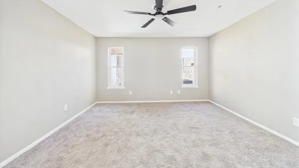 an empty room with windows and chandelier